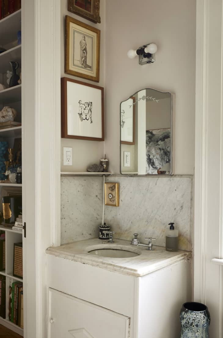 Sink area of framed artwork in the bathroom of a studio apartment.