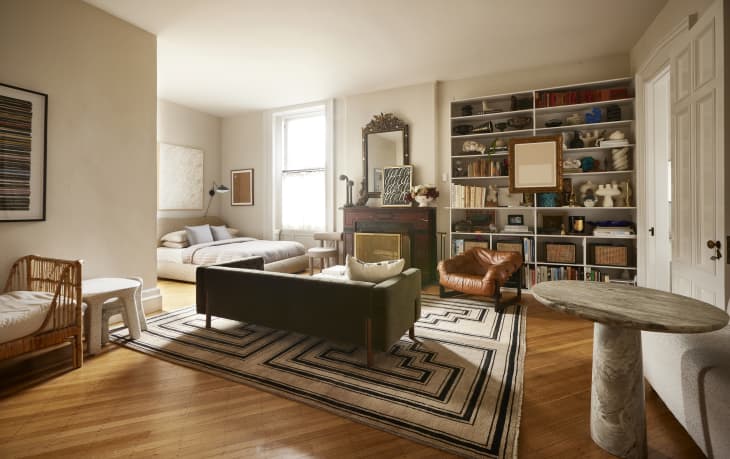 A studio apartment with a living area with a large area rug.