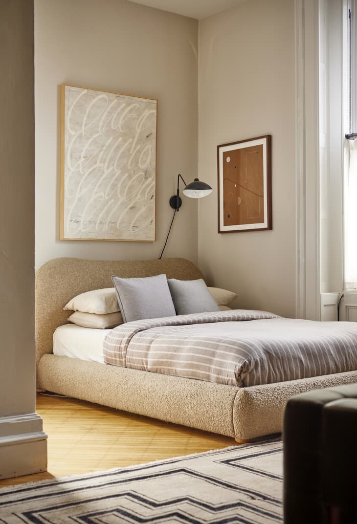 A neutral-colored sleeping area in a studio apartment.