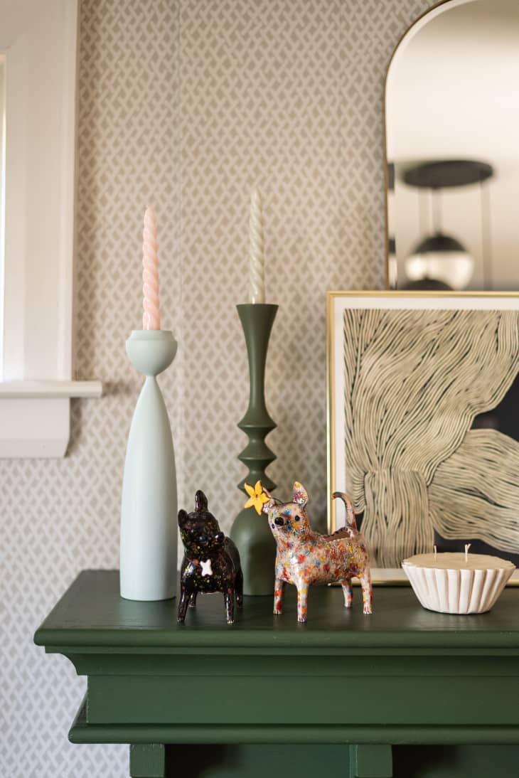 detail of candles and dog figurines on green mantel