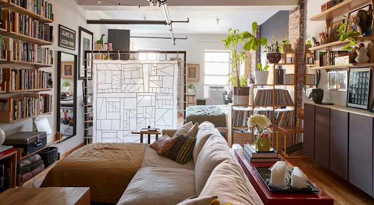 Living room with large white couch with a fabric room divider.