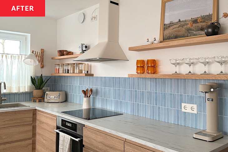 Renovated kitchen with light blue tiled backsplash, light wood cabinets with marble countertops and a kitchen island