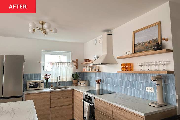 Renovated kitchen with light blue tiled backsplash, light wood cabinets with marble countertops and a kitchen island