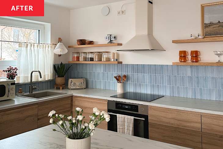 Renovated kitchen with light blue tiled backsplash, light wood cabinets with marble countertops and a kitchen island