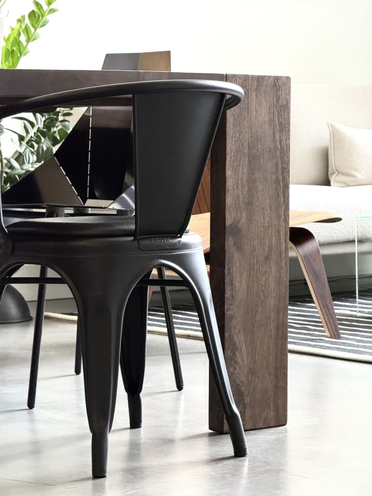 Dark wooden table with modern black metal chairs.