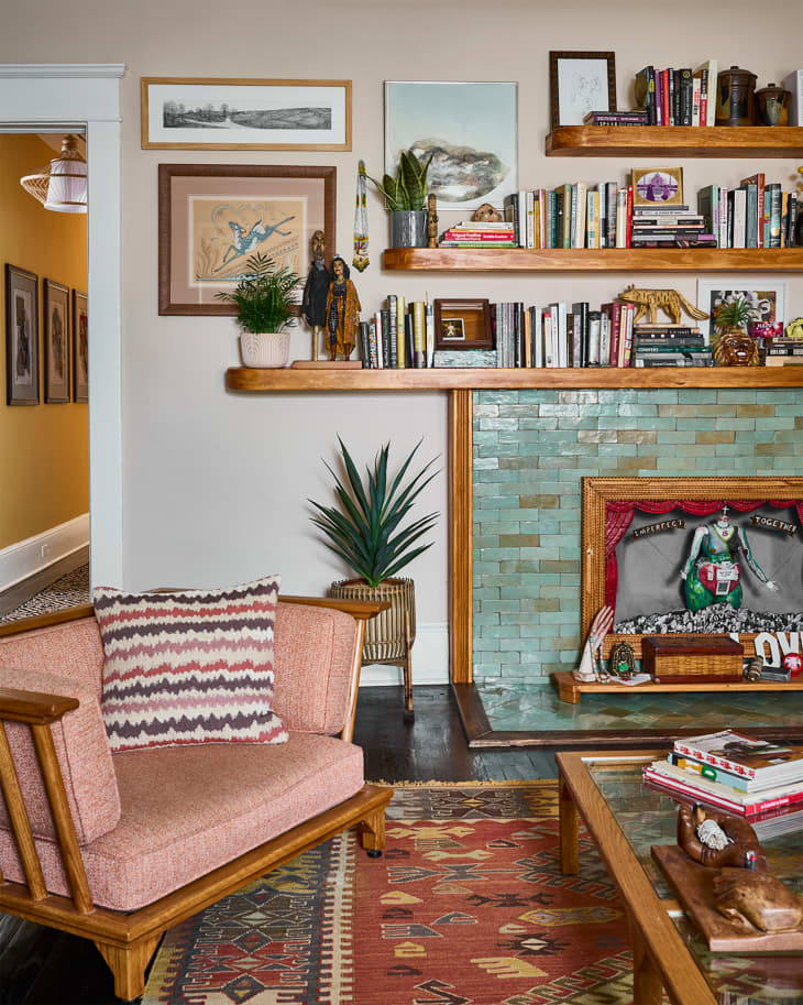 Green bricks in front of living room fireplace with book filled shelves on top.