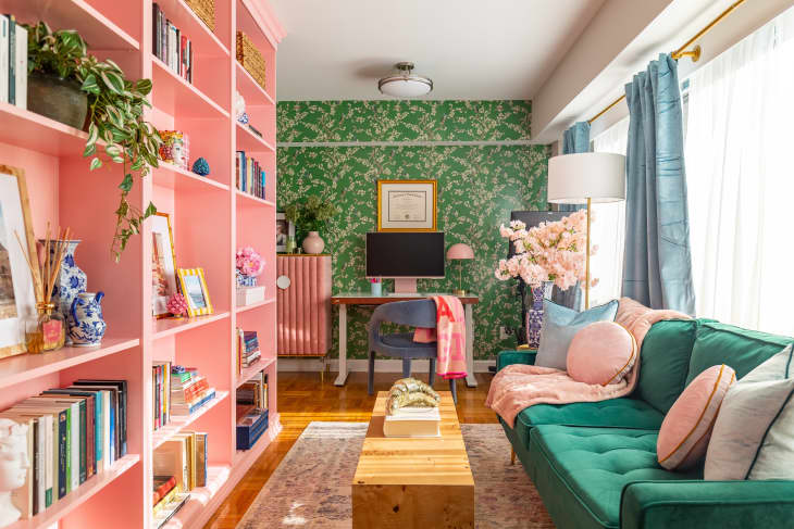 Pink bookshelf in colorful living room.