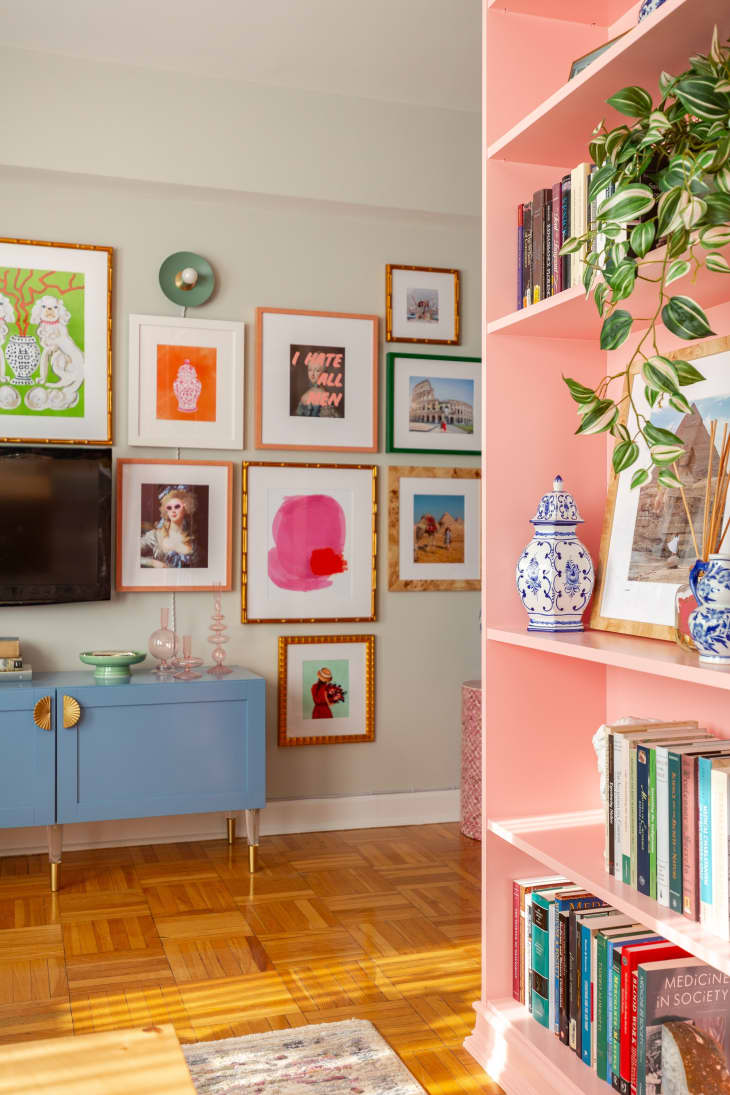 A gallery wall next to built-in pink book case.