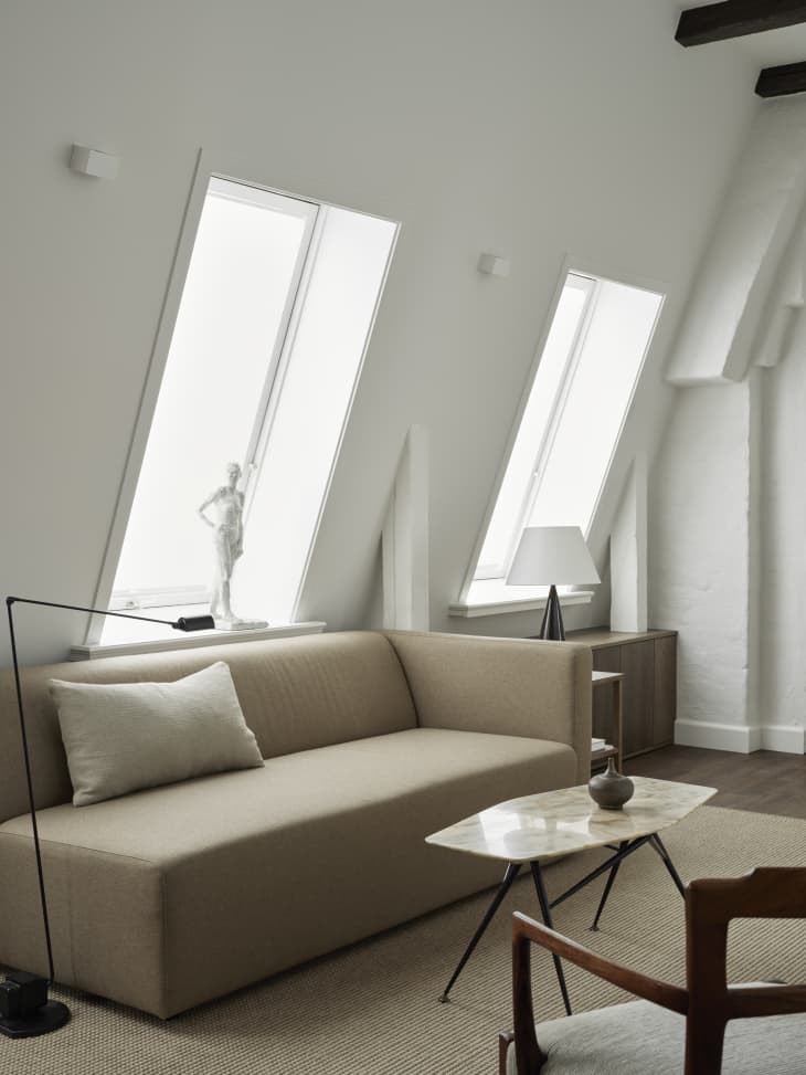 angled walls with large windows, beige couch