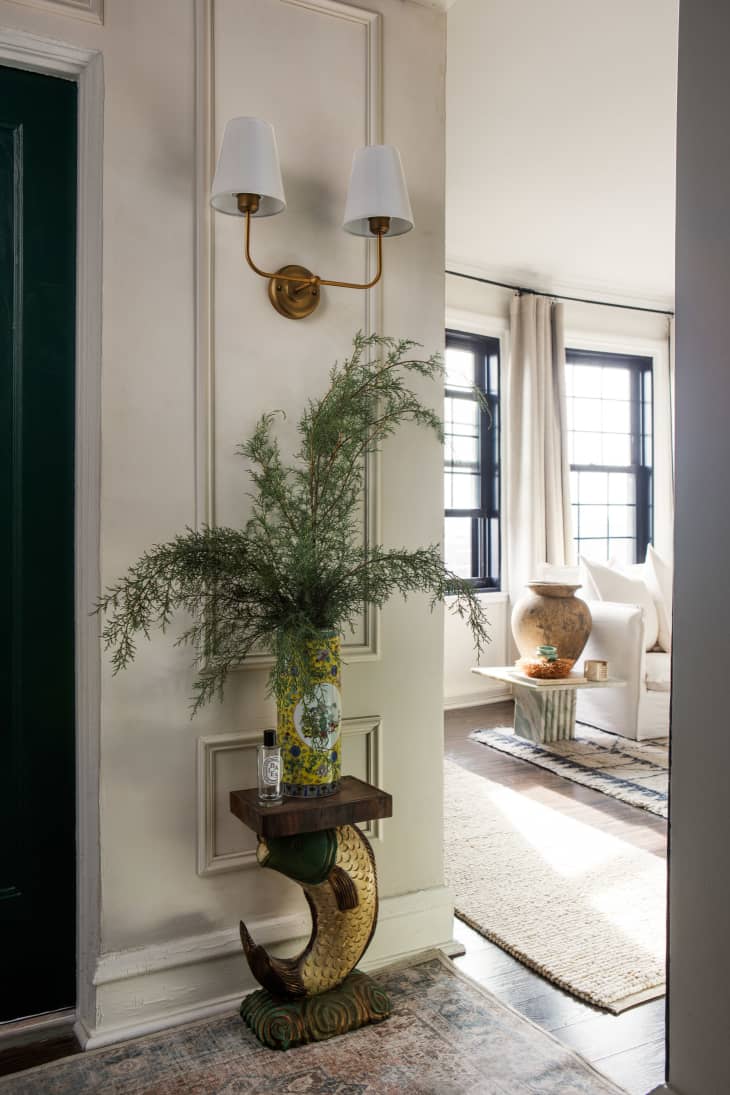 White hallway with decorative accent table and plant