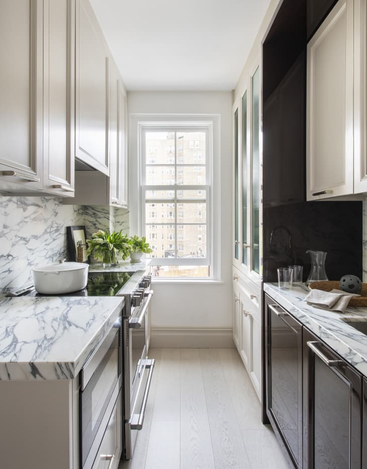 white kitchen with marble countertop and backsplash
