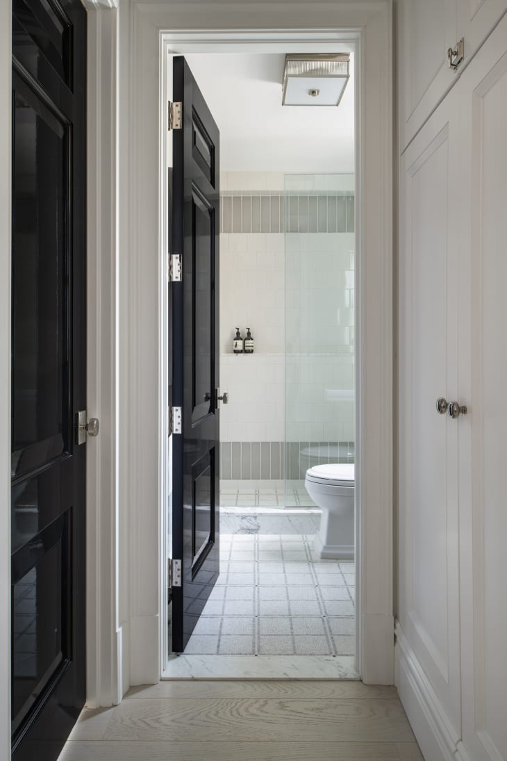 white and gray tiled bathroom viewed from the hallway