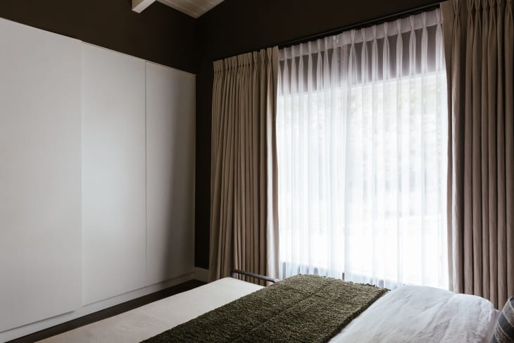 Curtains in dark painted bedroom.