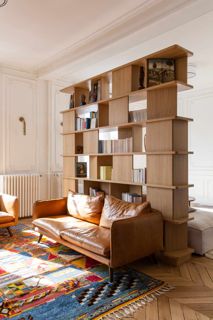 Large wooden bookcase in living room with cognac leather seating.