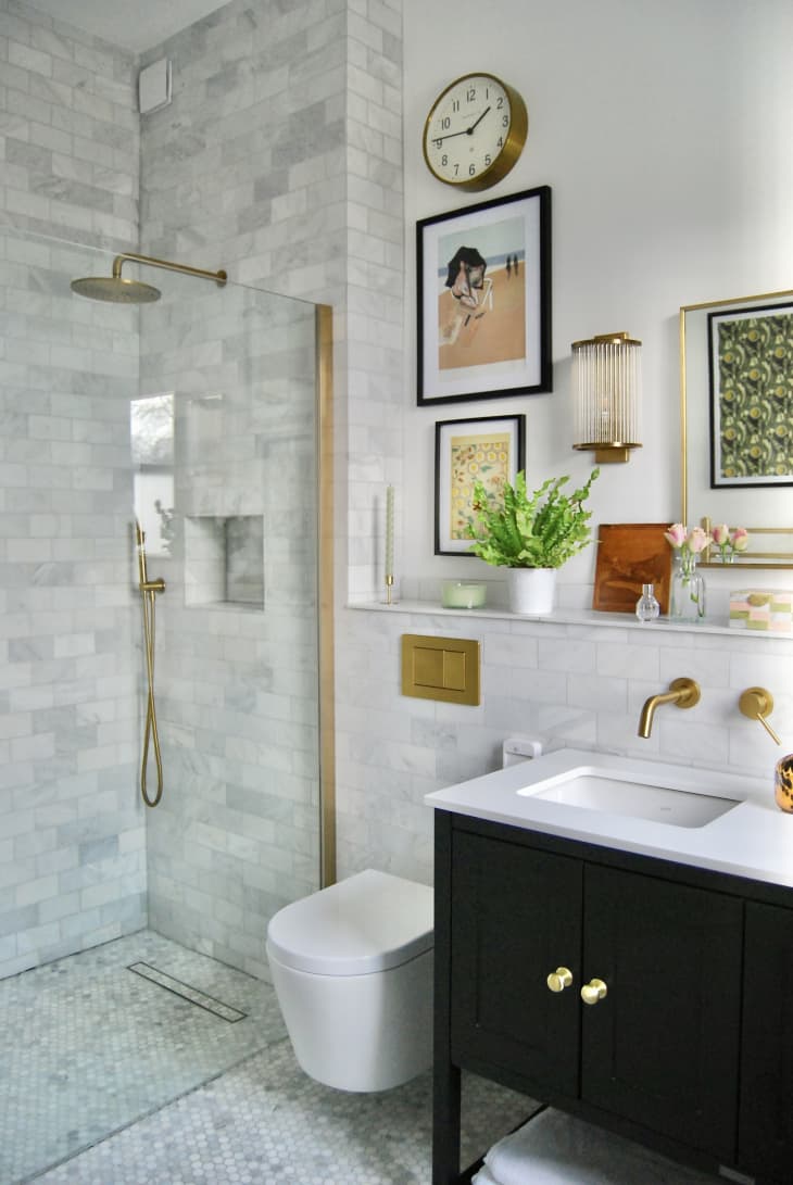 Bathroom with marble tile and golden fixtures.