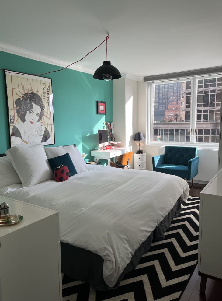 teal and white bedroom with black and white rug and large paned windows