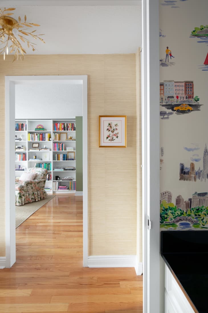 Hallway, wood floors, view of living room floor to ceiling book shelves
