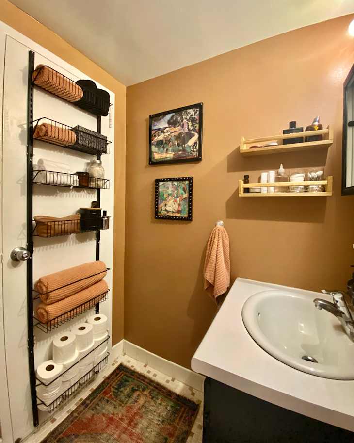 Medium brown bathroom with black cabinets and hanging storage