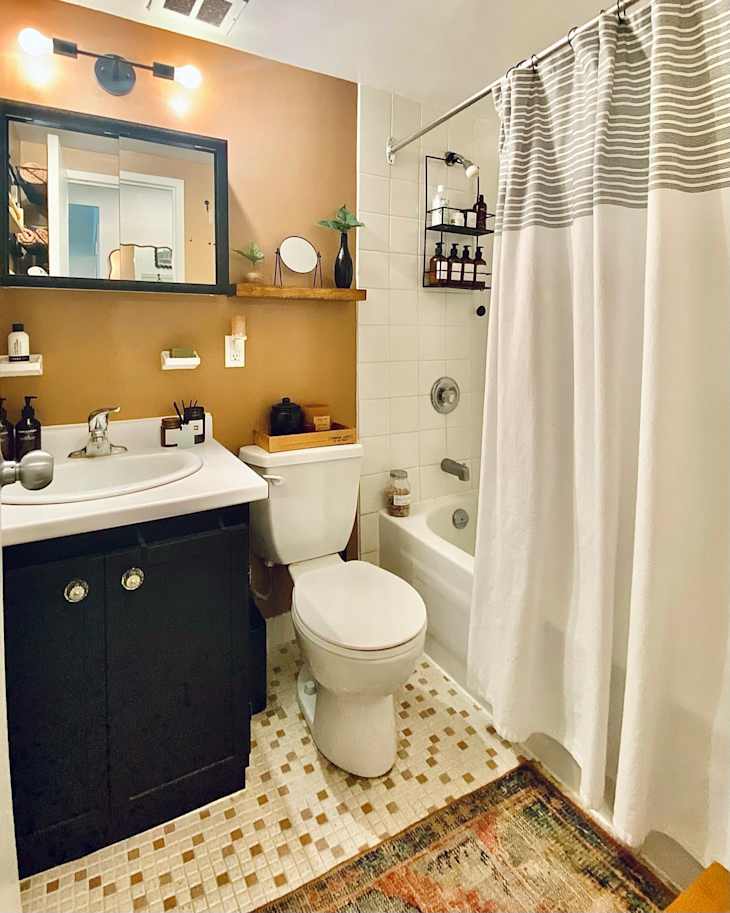 Medium brown bathroom with black cabinets, hanging storage and shower-bathtub