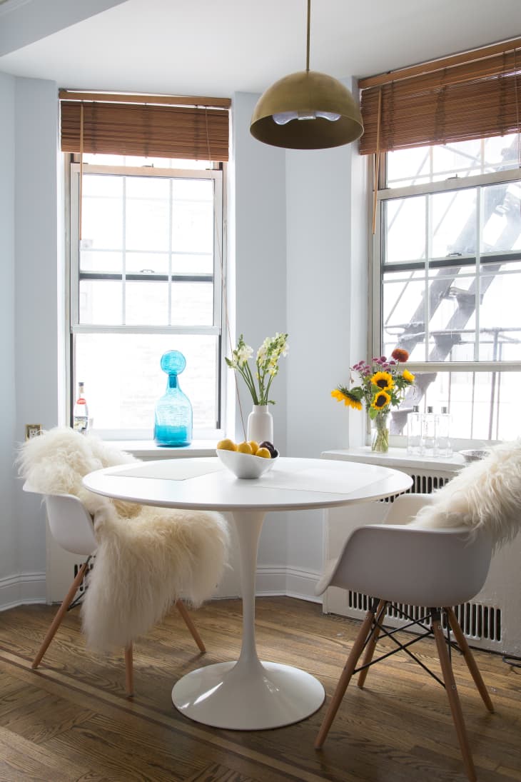 A dining room table with sheepskin throws