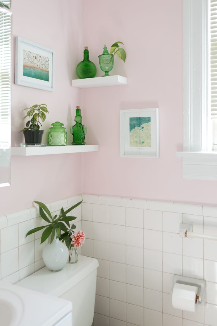 Two white floating shelves are hung up in a small bathroom as a space-saving measure