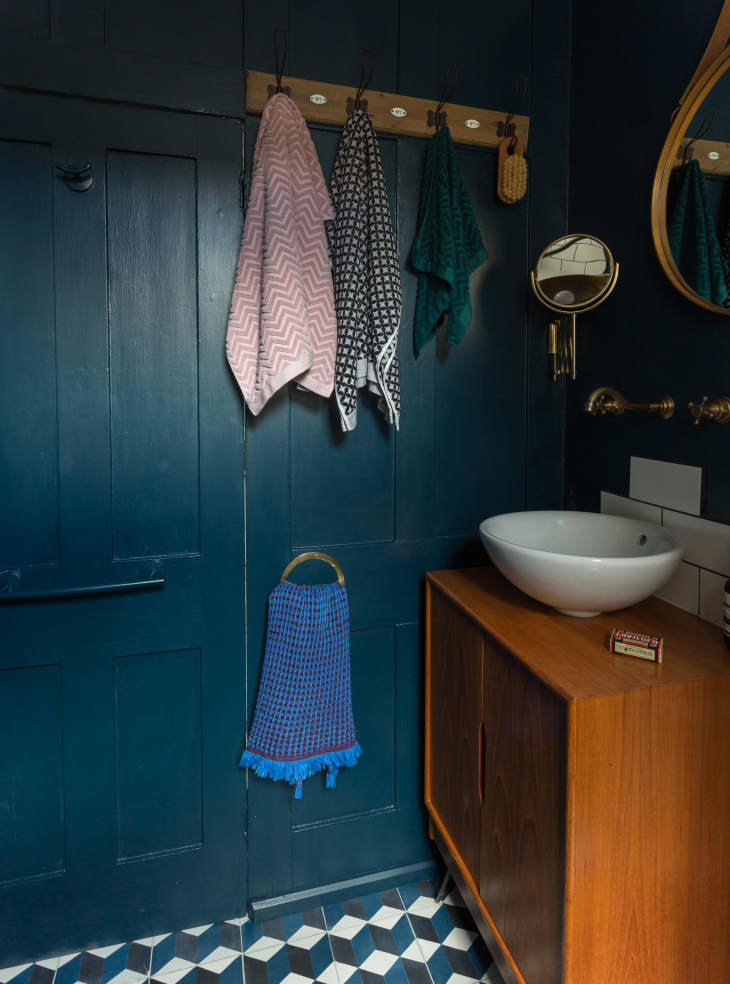 Half bathroom with dark blue wall paint and floor tiles