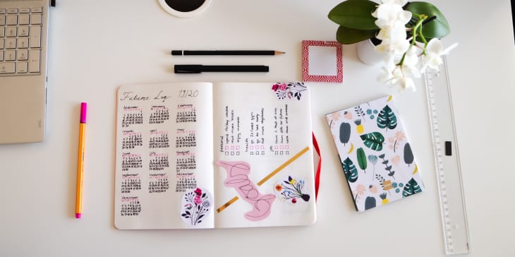Karlsruhe, Germany - 11.11.2019: Journal life style, Bullet Journal - Planer - Notebook - top view with utensils arranged on white background, orchid, pencils, sticky notes