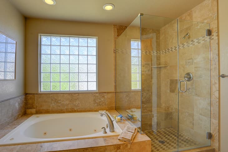 Beige bathroom with jacuzzi tub and glass block window