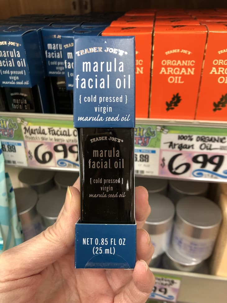 Someone holding up bottle of Marula Facial Oil at Trader Joe's store