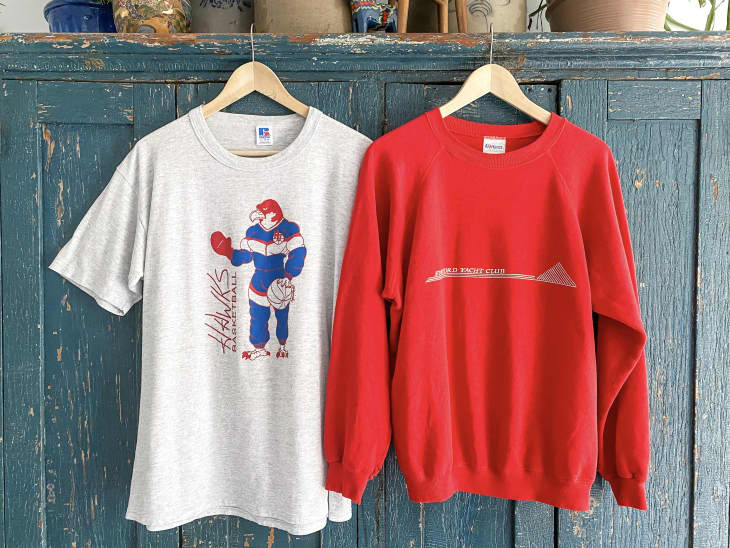 t-shirt and sweatshirt hanging in antique store
