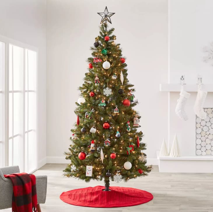 Christmas tree with ornaments, star on top, and red tree skirt