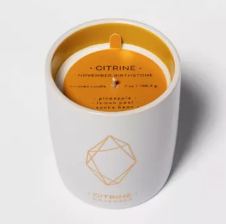 Citrus-scented candle in white vessel