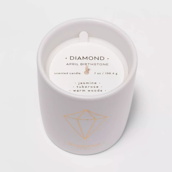 Jasmine and wood-scented candle in white vessel