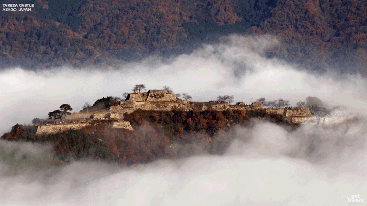Takeda castel appearing in foggy, mountainous area