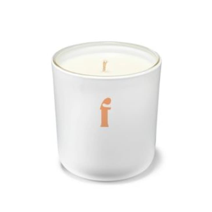 White candle with orange 'f' on the jar
