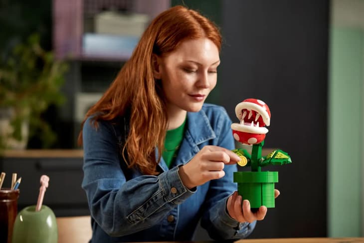 woman holding man eating lego in a green room