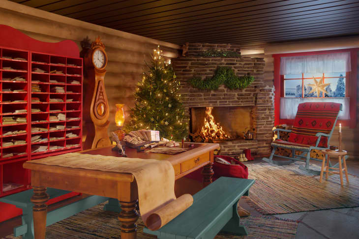 red letter slot wall, wood table with teal wood bench and brick fireplace with christmas tree and decorations, red rocking chair