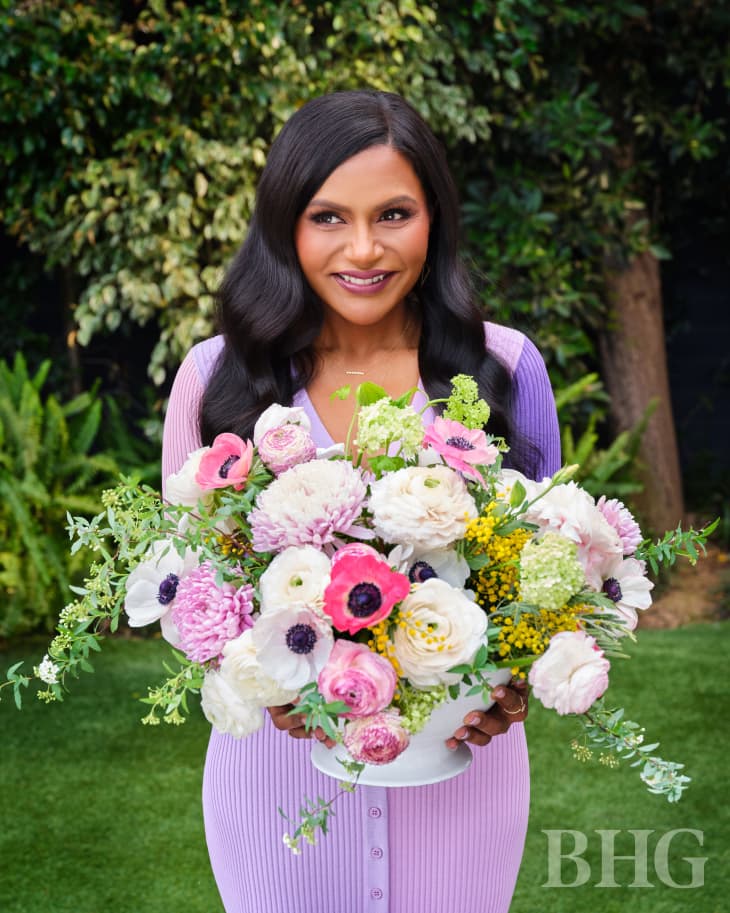Mindy Kaling holding bouquet of flowers.