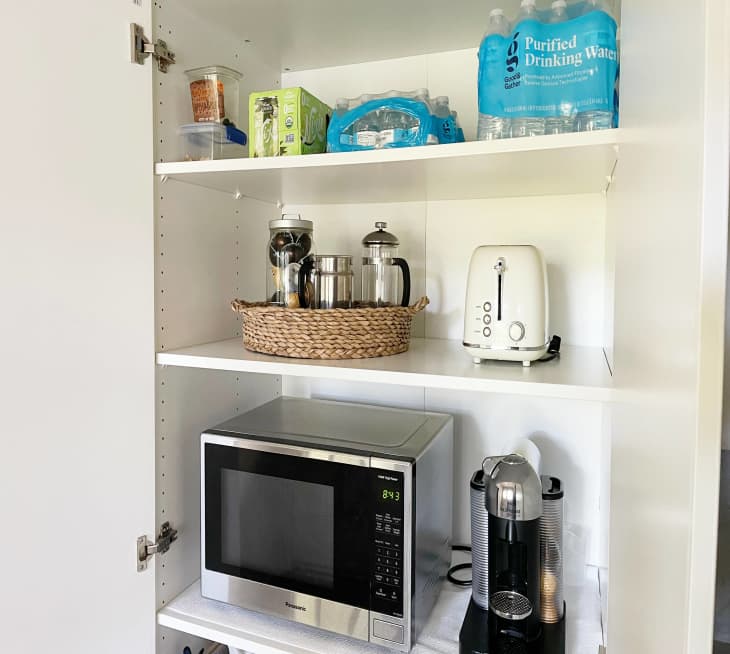 Pax pantry with bottled water, storage containers and appliances