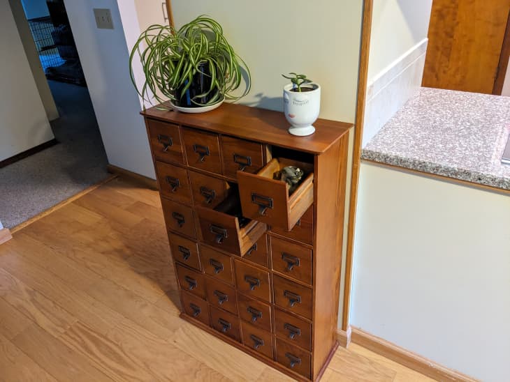 Wood library catalog cabinet in home holding various collections in each drawer