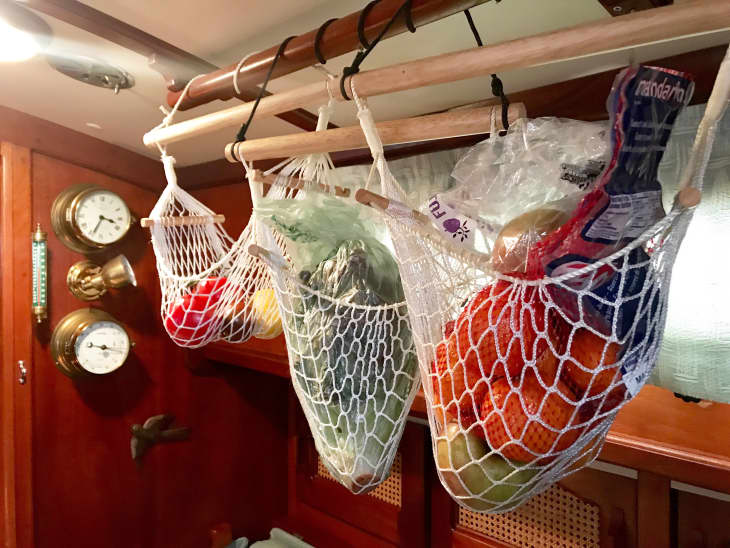 food being stored in sailboat via net 