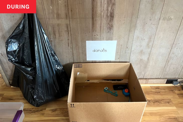 Cardboard box with donate sign above while using core four organizing method.