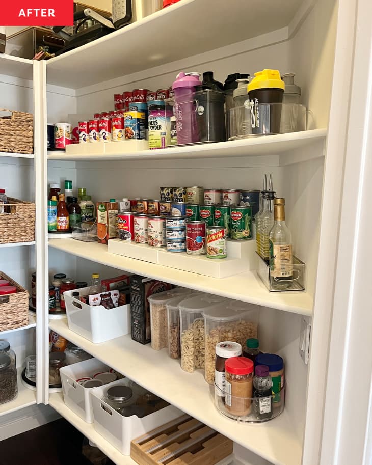 Organized food pantry with cans stacked on shelf organizer.