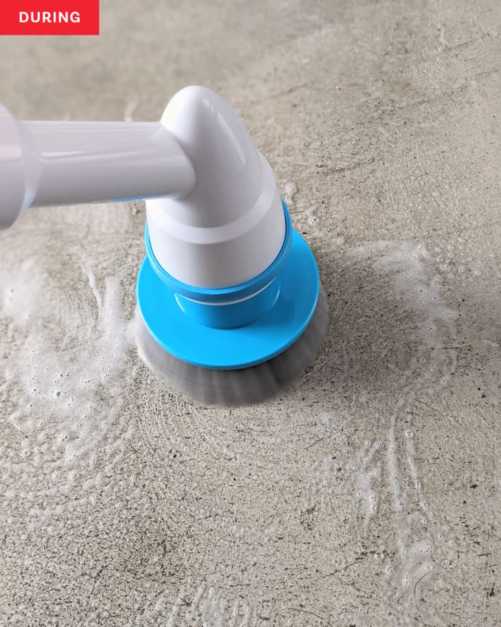 Cement kitchen floor being cleaned with Oraimo Electric Spin Scrubber