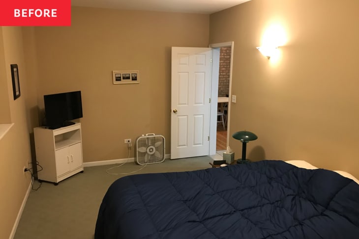 Small bedroom with blue comforter on bed before apartment renovation and expansion.