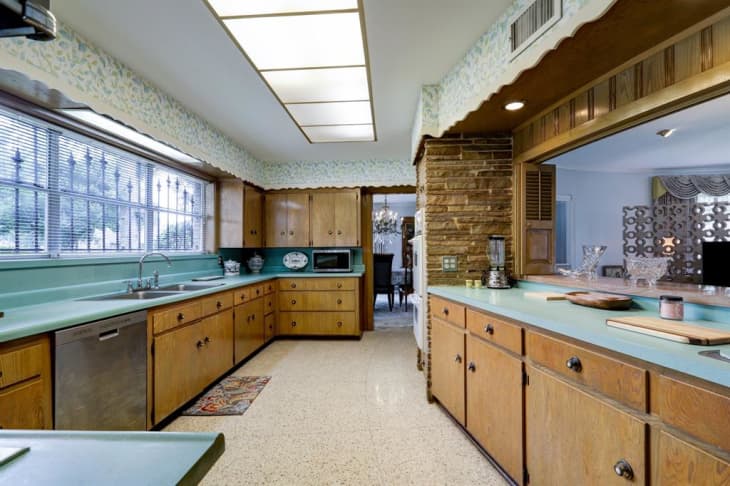 A large kitchen with blue counters and wooden cabinets