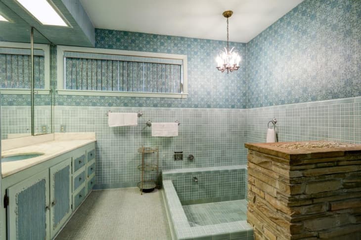 A blue tiled bathroom with a large tiled tub