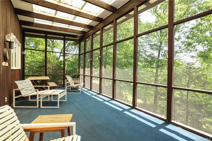Sun porch overlooking the woods of a mid-century modern home.