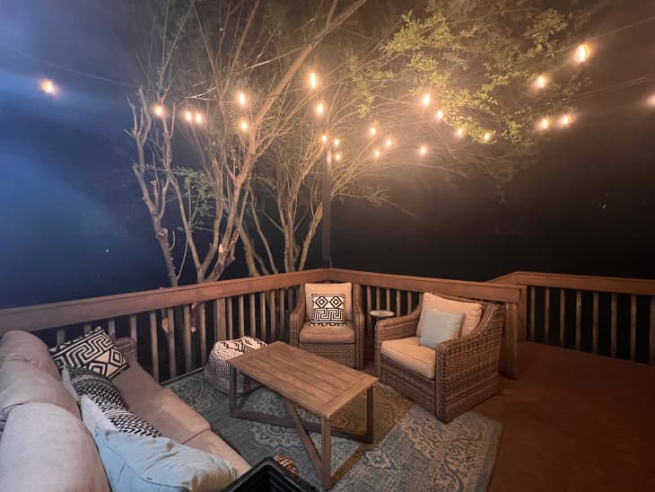 String lights hung in outdoor patio area with wicker armchairs.