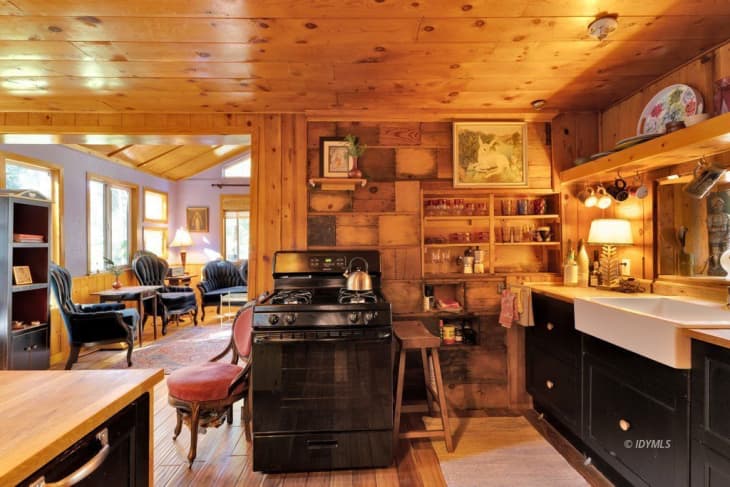Kitchen in cabin with wood walls and celiing and lots of open shelves